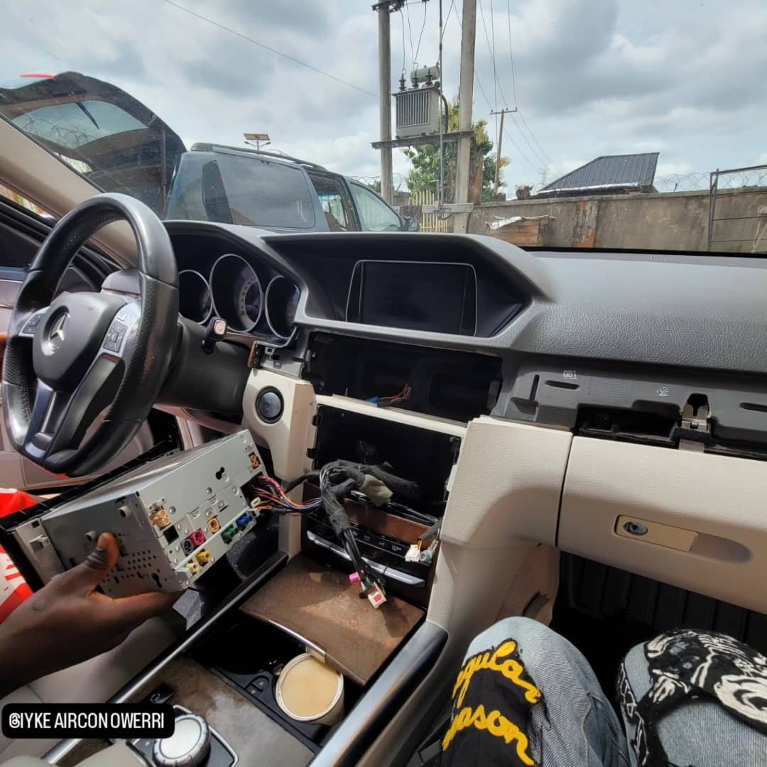 GEIYKE technician removing a vehicle dashboard unit for programming